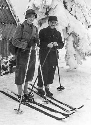 Zwei Männer auf Ski in einem verschneiten Wald