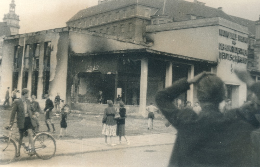 Menschen vor dem ausgebrannten Pavillon der Nationalen Front auf dem Leipziger Marktplatz